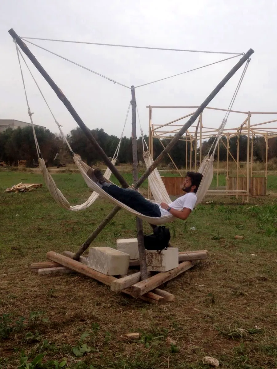 Raffaele lying in one of the hammocks of the finished frame in the field