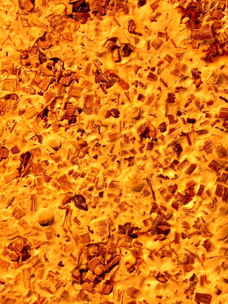 The seat's surface lit orange from behind, the substrate full of holes